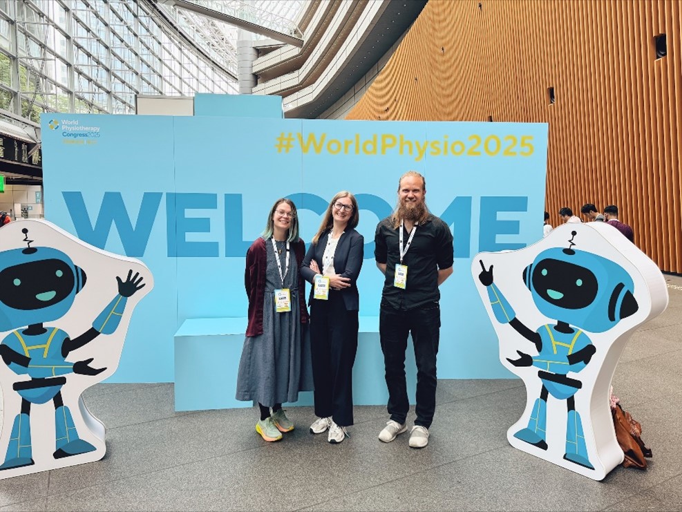 En gruppe mennesker som poserer for et bilde foran et skilt