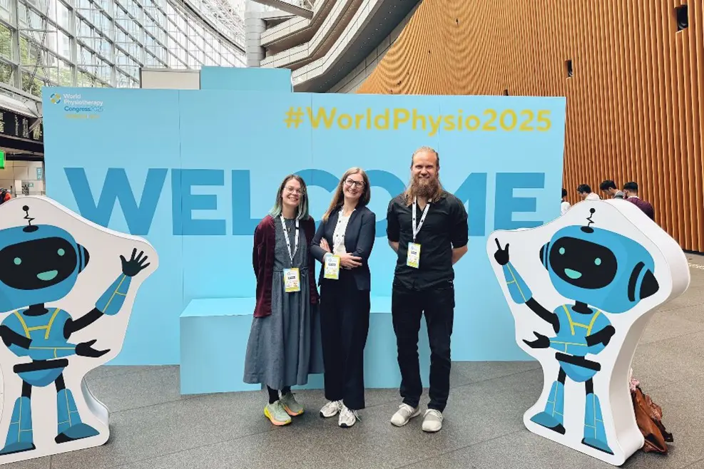 En gruppe mennesker som poserer for et bilde foran et skilt