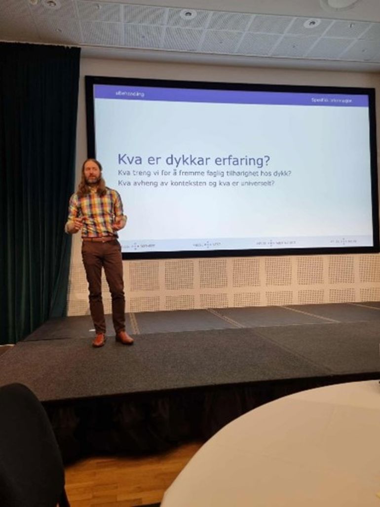 En person som står foran en projektorskjerm