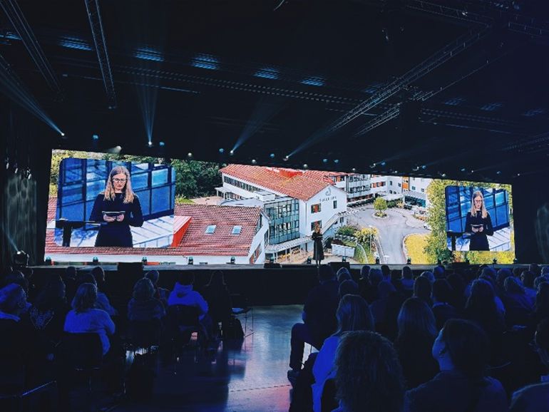 En gruppe mennesker som ser på en person på en scene