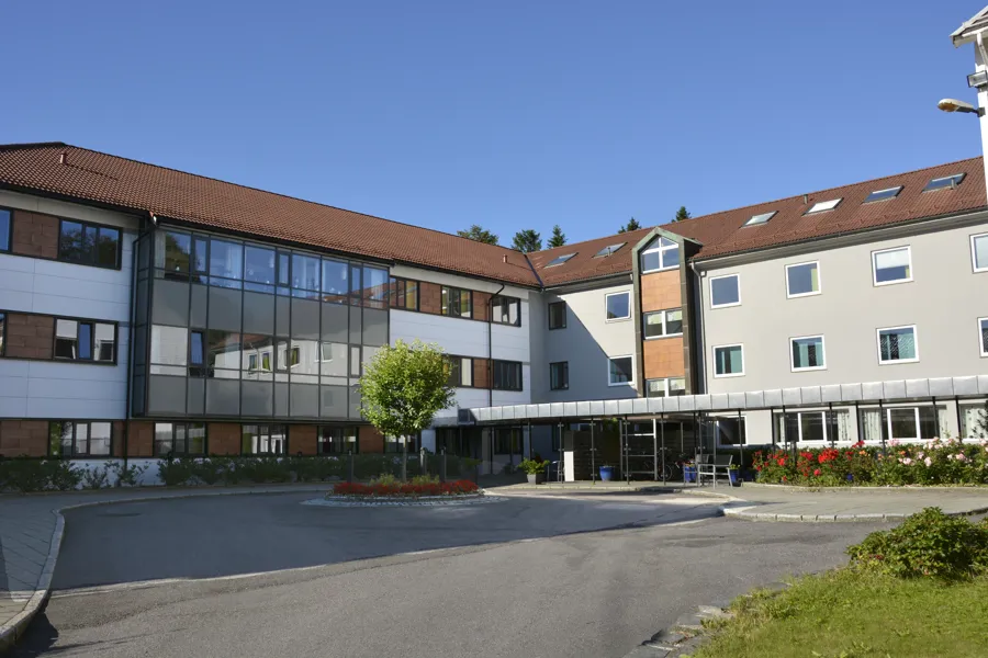 Bygg med rødt tak og blå himmel i bakgrunnen